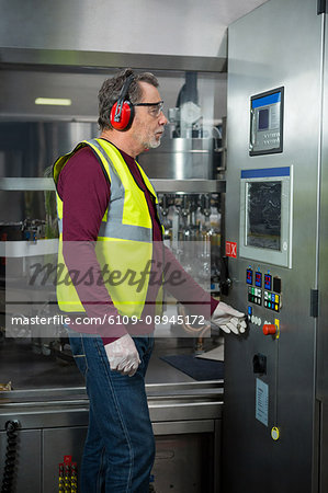 Senior manual worker analyzing machinery in factory