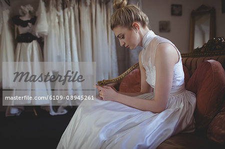 Young bride using mobile phone in a boutique Young bride using mobile phone in a boutique