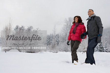 Mature couple walking through snow
