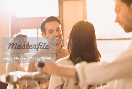 Smiling man talking to woman in bar