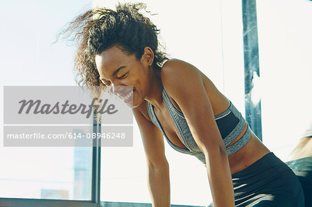 Young woman in gym, laughing