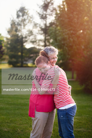 Portrait of mother and adult daughter, hugging