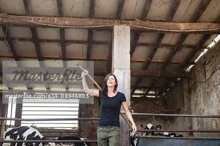 Female organic farmer with pitch fork over her shoulder on dairy farm