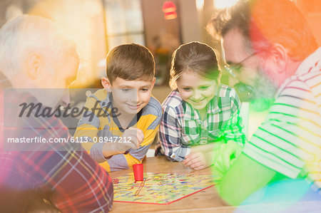 Male gay parents and children playing board game