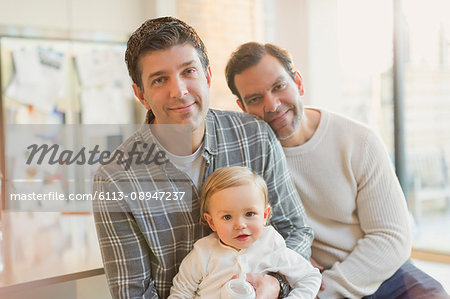 Portrait smiling male gay parents with baby son