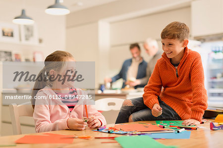 Brother and sister doing crafts at table