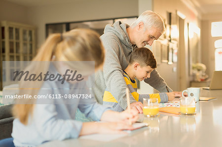 Father helping son with homework at counter