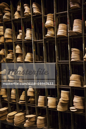 Close up of leather soles on shelves in a shoemaker's workshop.