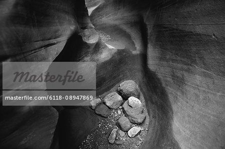 A slot canyon, deep fissure, viewed from above with boulders at the base. Little Wildhorse Canyon, Goblin Valley State Park.