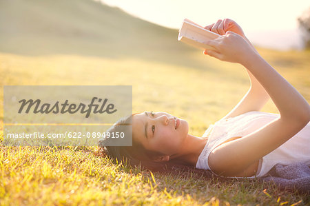 Young Japanese woman in a white dress at a cliff over the sea at sunrise, Chiba, Japan