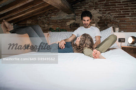 Romantic young couple reclining on bed