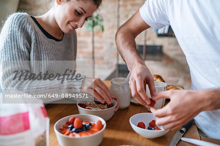 Young couple preparing breakfast together at kitchen counter