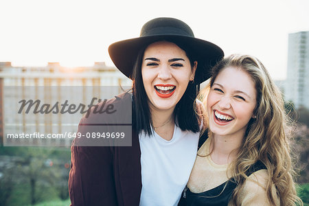 Portrait of two young women, on roof, smiling