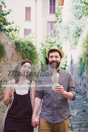 Portrait of couple with ice cream cones on cobbled street, Arezzo, Tuscany, Italy