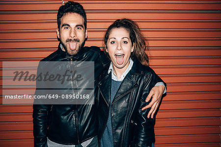 Couple sticking out tongue