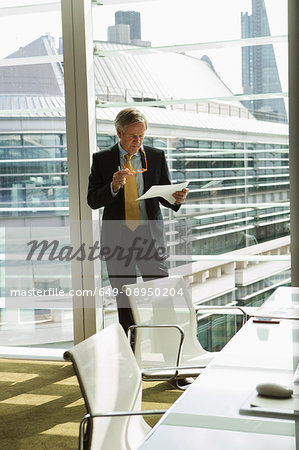 Businessman reading and analysing report, London, UK