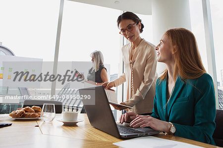Businesswomen preparing presentation in meeting room