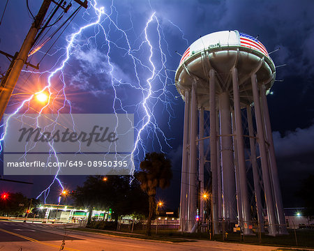 Spectacular lightning bolt with simultaneous branches strikes Cocoa, Florida, amid power lines near the city's water tower
