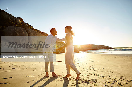 Mature couple on beach, standing face to face, Cape Town, South Africa