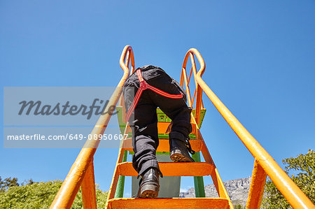 Boy climbing up slide in playground