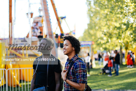 Two male friends at funfair, smiling