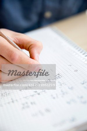 Teenager writing in textbook