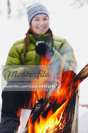 Smiling woman by fireplace