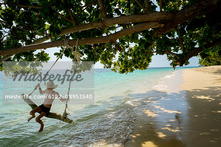 Boy swinging on beach