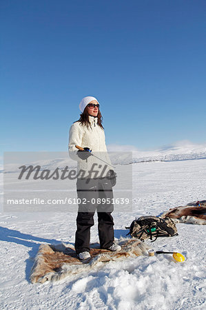 Young woman ice fishing