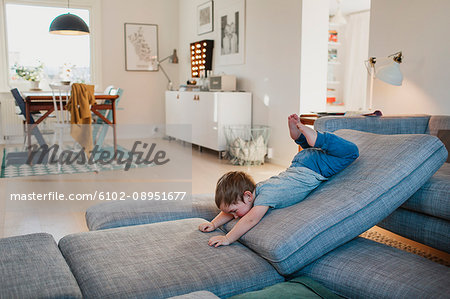 Boy playing on sofa pillows