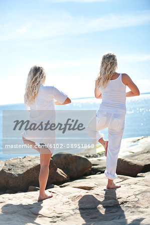 Women doing yoga at sea