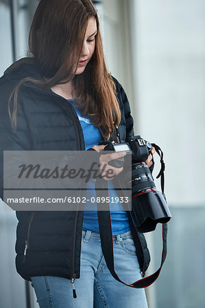 Teenage girl looking at digital camera