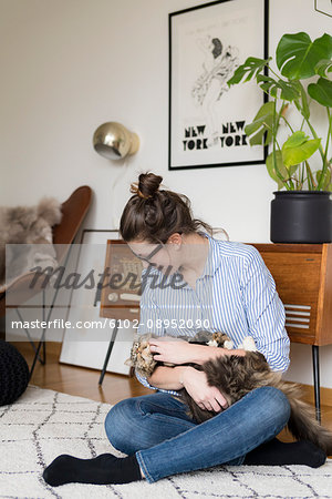 Young woman playing with cat