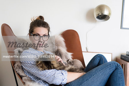 Young woman playing with cat