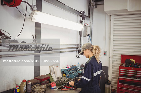 Female mechanic arranging tools