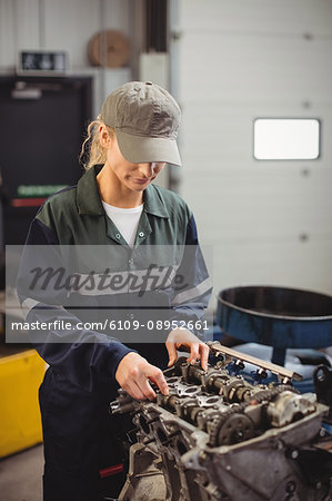Female mechanic checking a car parts