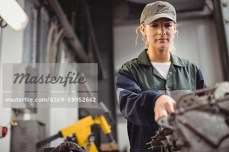 Female mechanic checking a car parts