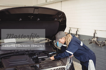 Female mechanic servicing car