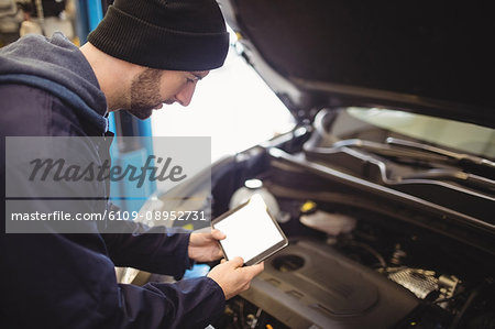 Mechanic using digital tablet on car