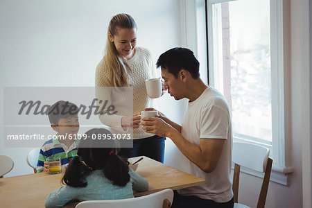 Woman serving coffee to man