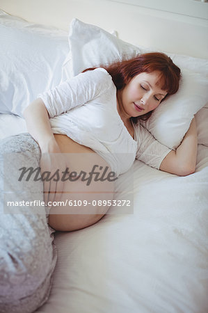 Pregnant woman relaxing on bed