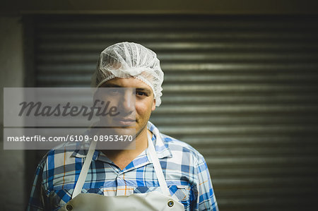 Portrait of male worker wearing protective headdress at beekeeping factory