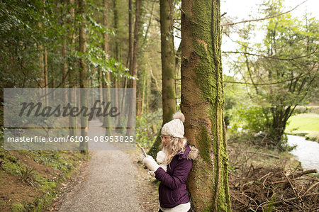 Woman using mobile phone in the forest