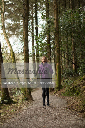 Beautiful woman jogging in forest