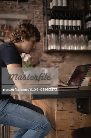 Attentive man using laptop in Café