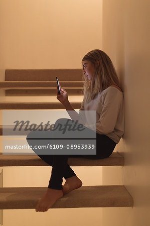 Beautiful woman using mobile phone at home