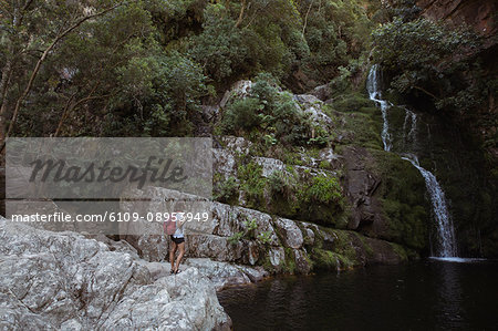 Woman standing near waterfall in countryside