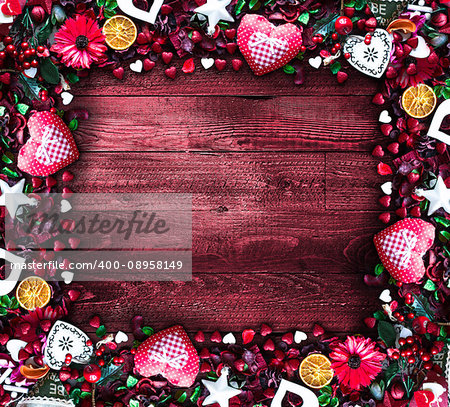 Valentine's Day Background with love themed elements like cotton and paper hearts, flowers, berries, oranges and other decorations. Wooden old parquet on the back.