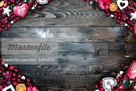 Valentine's Day Background with love themed elements like cotton and paper hearts, flowers, berries, oranges and other decorations. Wooden old parquet on the back.