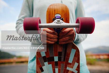 girl with longboard in hands closeup